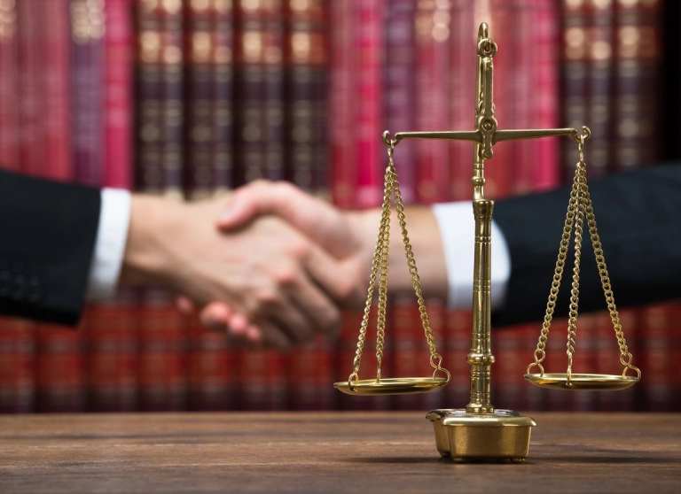 A judge 's desk with two people shaking hands.