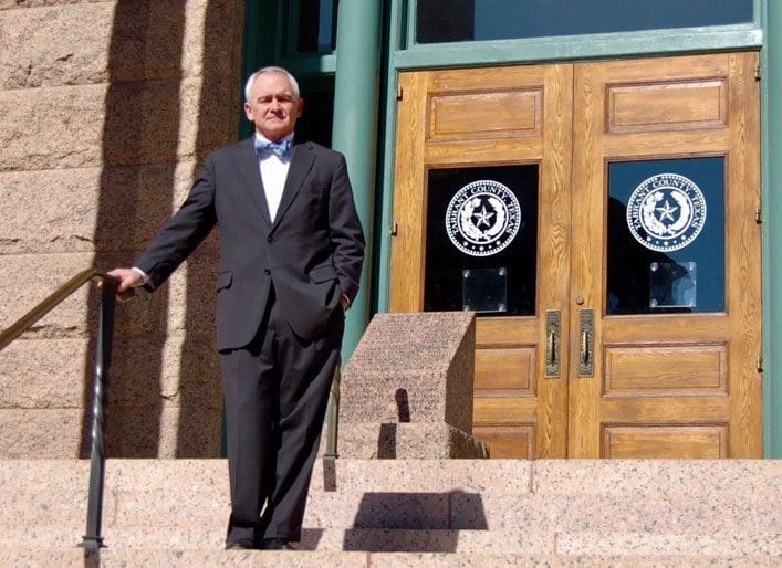 A man in a suit standing on steps outside of a building.